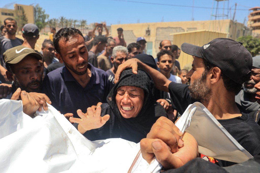 A Palestinian woman reacts over the corpse of a family member in front of the morgue of the Nasser hospital in Khan Yunis on July 13, 2024.