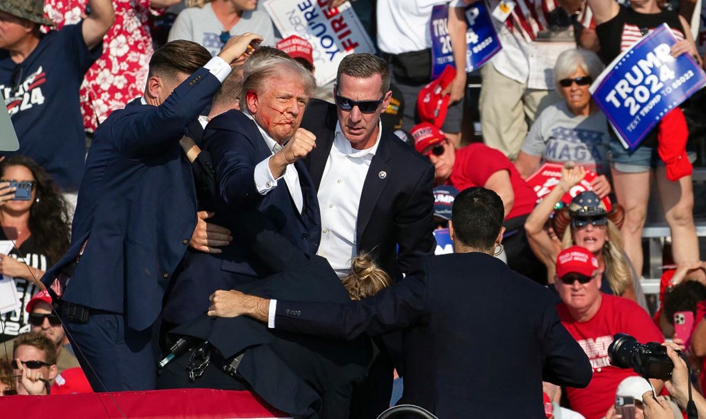 Republican presidential candidate former President Donald Trump pumps his fist as he is helped off the stage at a campaign event in Butler, Pa., on Saturday, July 13, 2024.