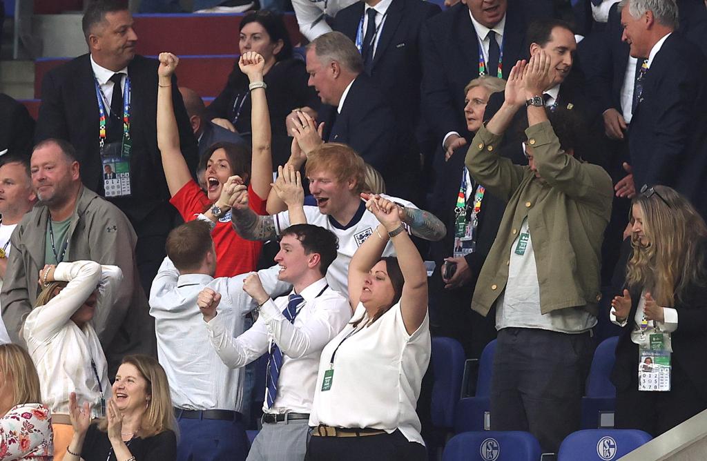 Ed Sheeran celebrating England's victory in UEFA Euro 2024 knockout stage match at Gelsenkirchen Stadium by punching the air in delight
