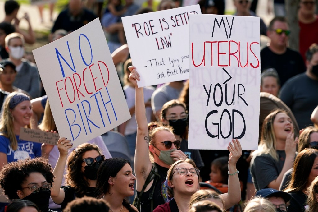 Abortion-rights protesters holding signs and cheering at a rally in Des Moines, Iowa following a controversial court decision on abortion laws