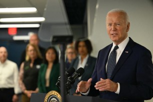 US President Joe Biden speaking about extreme weather at a DC Emergency Operations Center podium surrounded by microphones