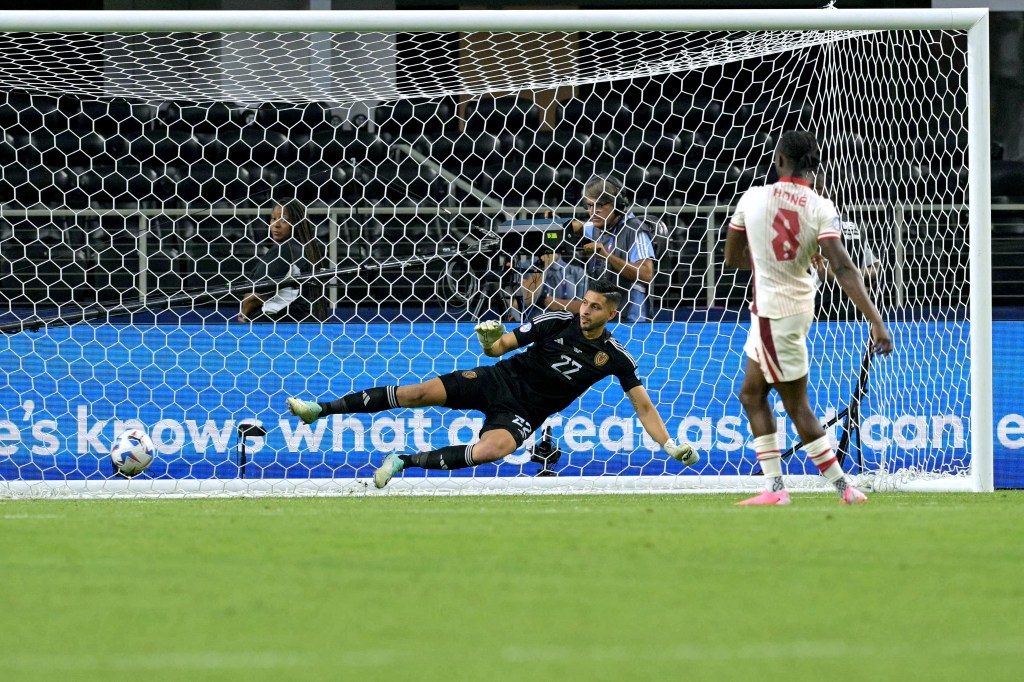 Canada's midfielder #08 Ismael Kone scores a goal as Venezuela's goalkeeper #22 Rafael Romo dives for the ball in a penalty shoot-out to win the Conmebol 2024 Copa America tournament quarter-final football match between Venezuela and Canada at AT&T Stadium in Arlington, Texas, on July 5, 2024. 