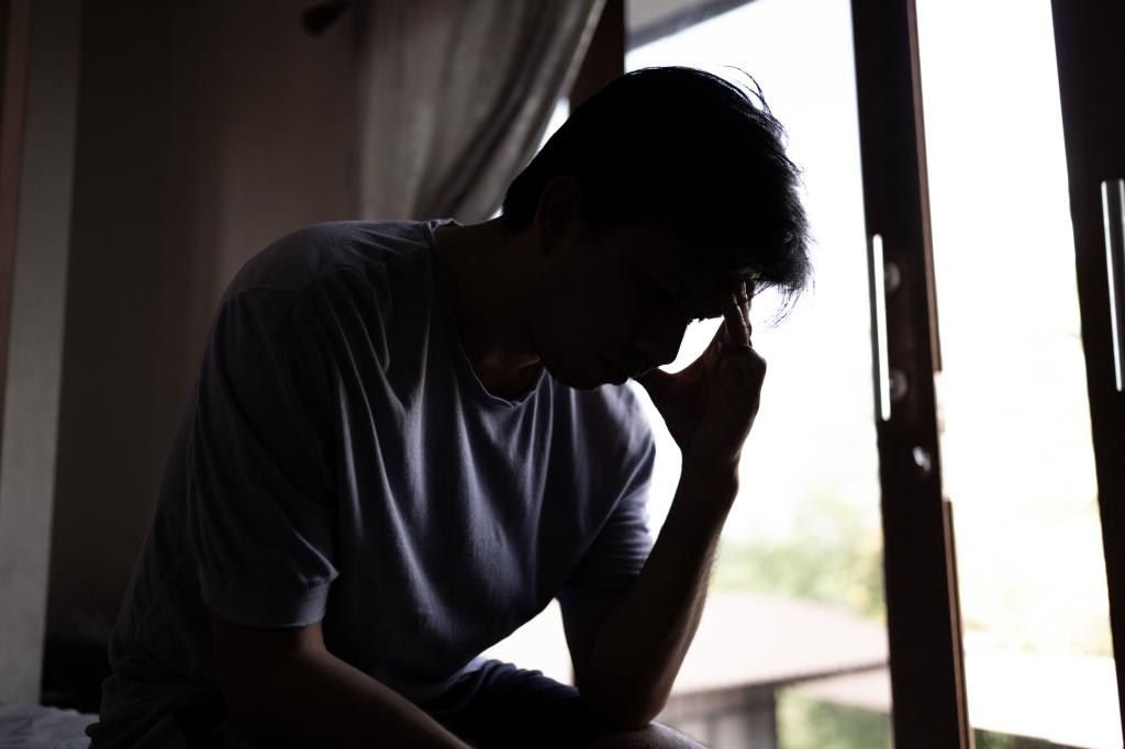 silhouette man sitting stressed out in the bedroom