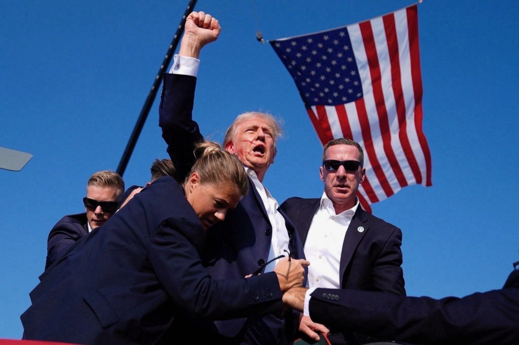 Donald Trump with a group of people standing in front of a flag