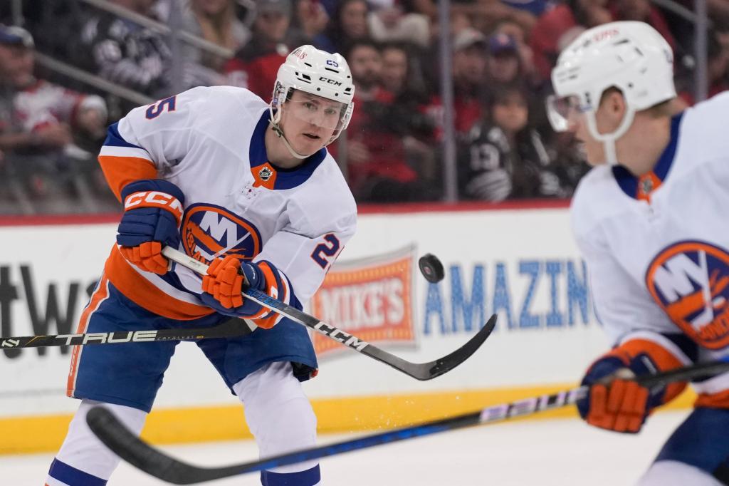 New York Islanders' Sebastian Aho, left, moves the puck up the ice during the first period of an NHL hockey game against the New Jersey Devils in Newark, N.J., Monday, April 15, 2024. 