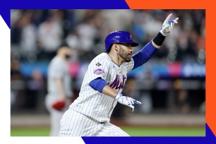 J.D. Martinez points to the sky triumphantly while rounding the bases.