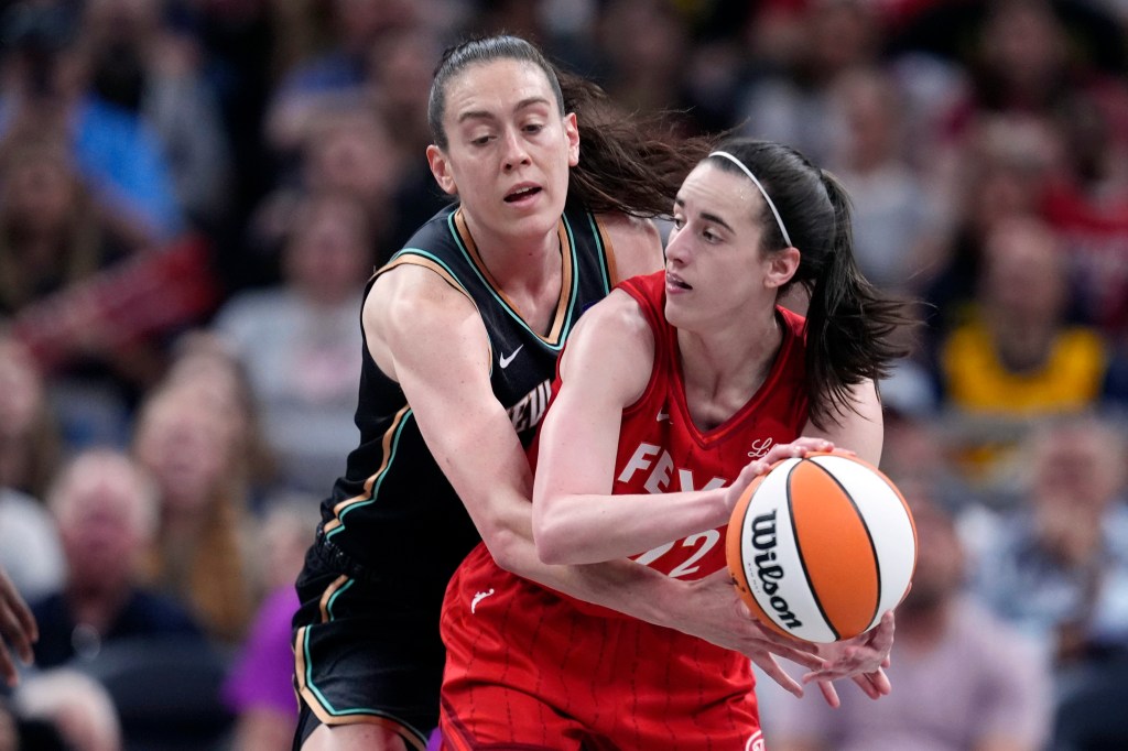 Indiana Fever's Caitlin Clark (22) makes a pass as New York Liberty's Breanna Stewart (30) defends
