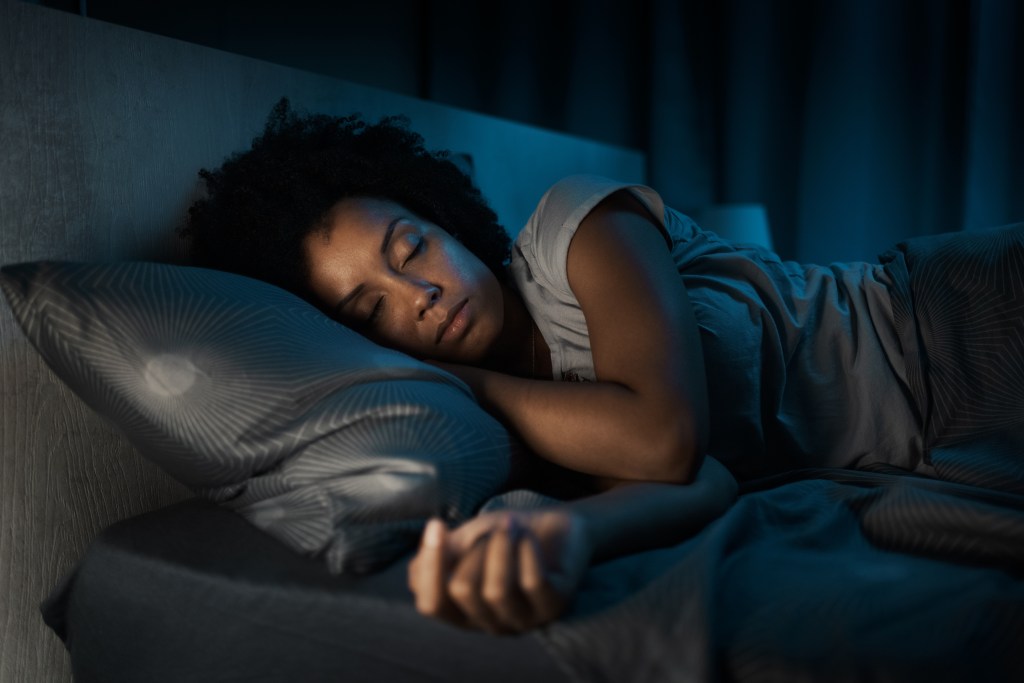 Beautiful african american woman sleeping in her bed at night