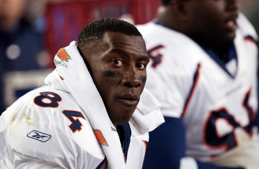 Shannon Sharpe of the Denver Broncos sitting on the bench during a game against the New England Patriots at Gillette Stadium in 2002