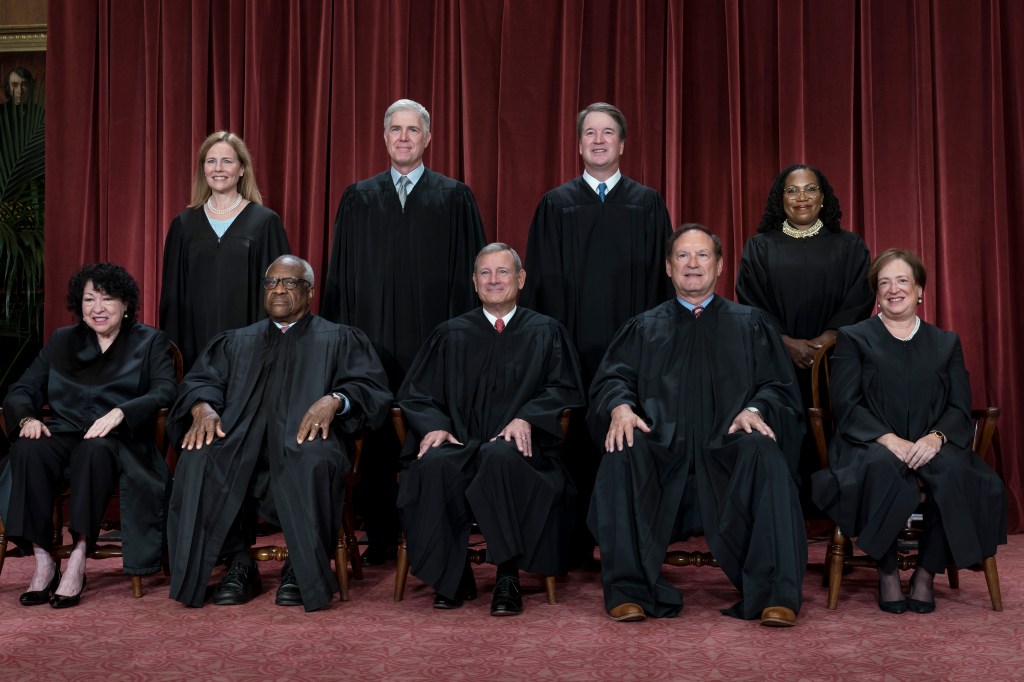 Group portrait of Supreme Court Justices in black robes, including Sonia Sotomayor, Clarence Thomas, John Roberts, and others, discussing their upcoming cases in Washington, 2022.