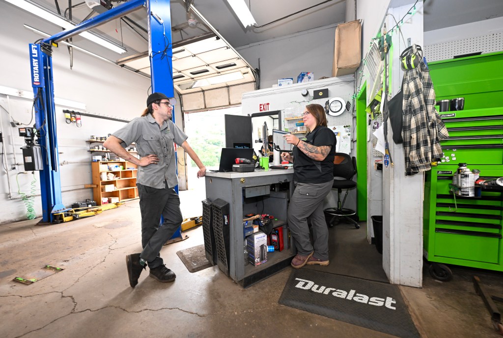 Victoria Carl in her shop talking to a mechanic