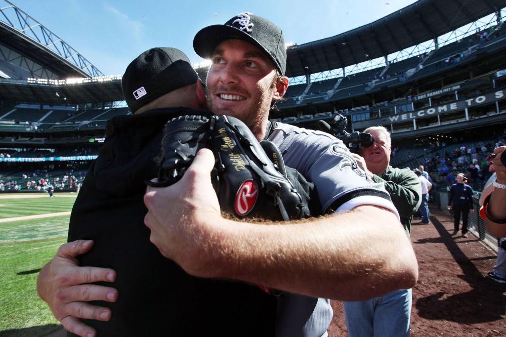 Chicago White Sox starting pitcher Phil Humber, front right, is embraced after pitching a perfect baseball game against the Seattle Mariners, Saturday, April 21, 2012, in Seattle. The White Sox won 4-0. 