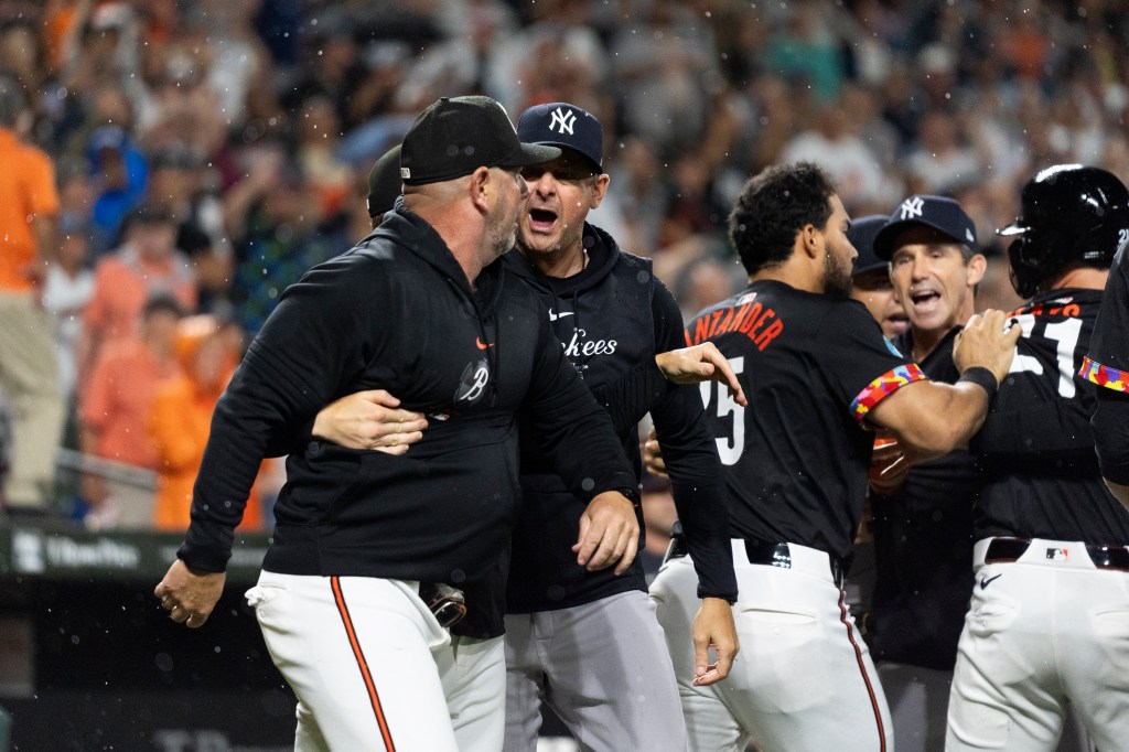 Yankees manager Aaron Boone, center, and Baltimore Orioles manager Brandon Hyde, left, argue after players cleared the benches during the ninth inning on Friday night.