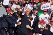 Secret Service agents rushing to get former President Donald Trump off the stage after the assassination attempt at a rally in Pennsylvania.