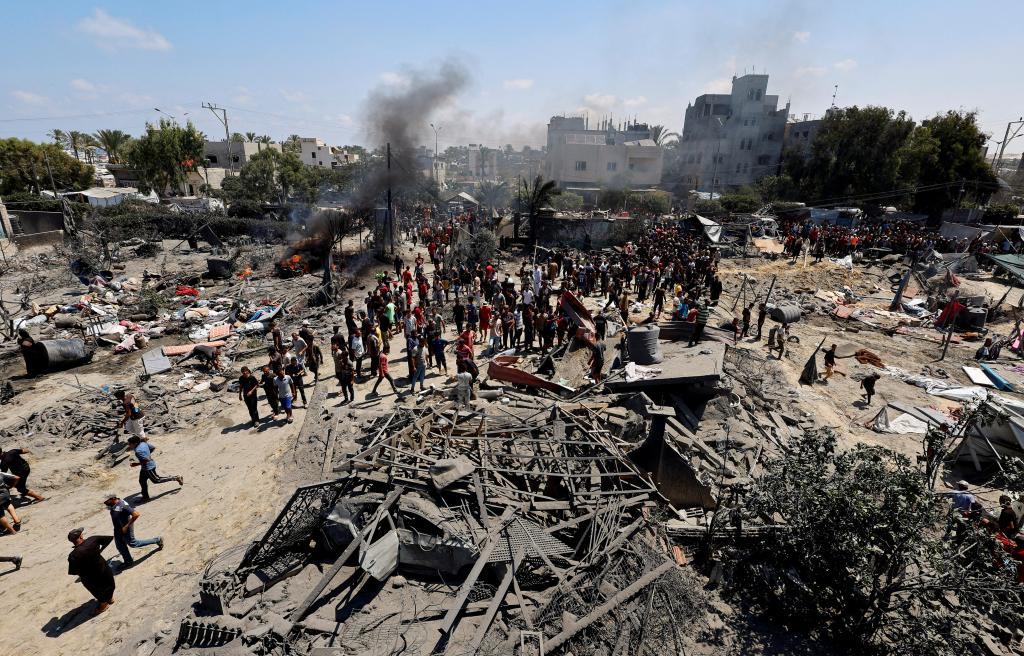 Palestinians gather near damage, following what Palestinians say was an Israeli strike at a tent camp in Al-Mawasi area, amid Israel-Hamas conflict, in Khan Younis in the southern Gaza Strip July 13, 2024. 