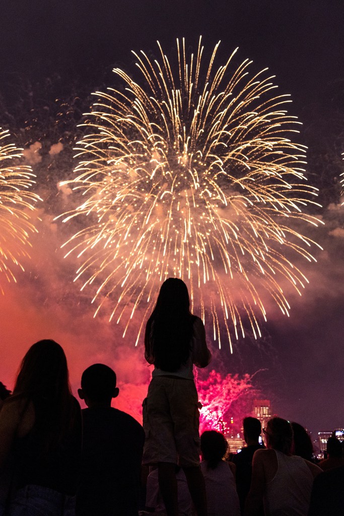 A child's silhouette is cast in front of the fireworks from a watch party in Hoboken, NJ on July 4, 2024. 