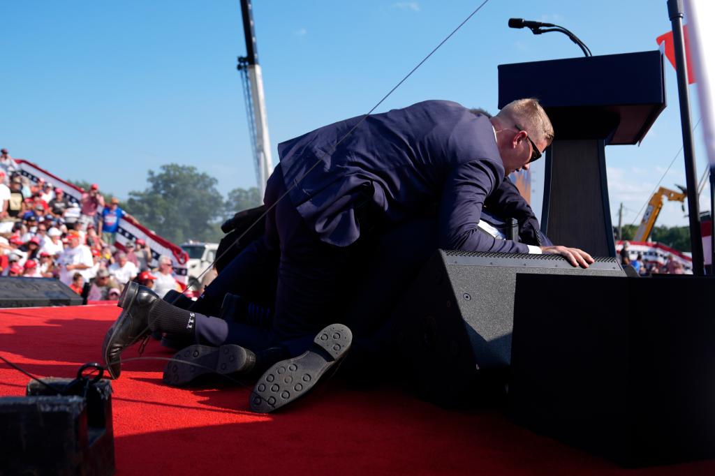 Republican presidential candidate former President Donald Trump is covered by U.S. Secret Service agents at a campaign rally,