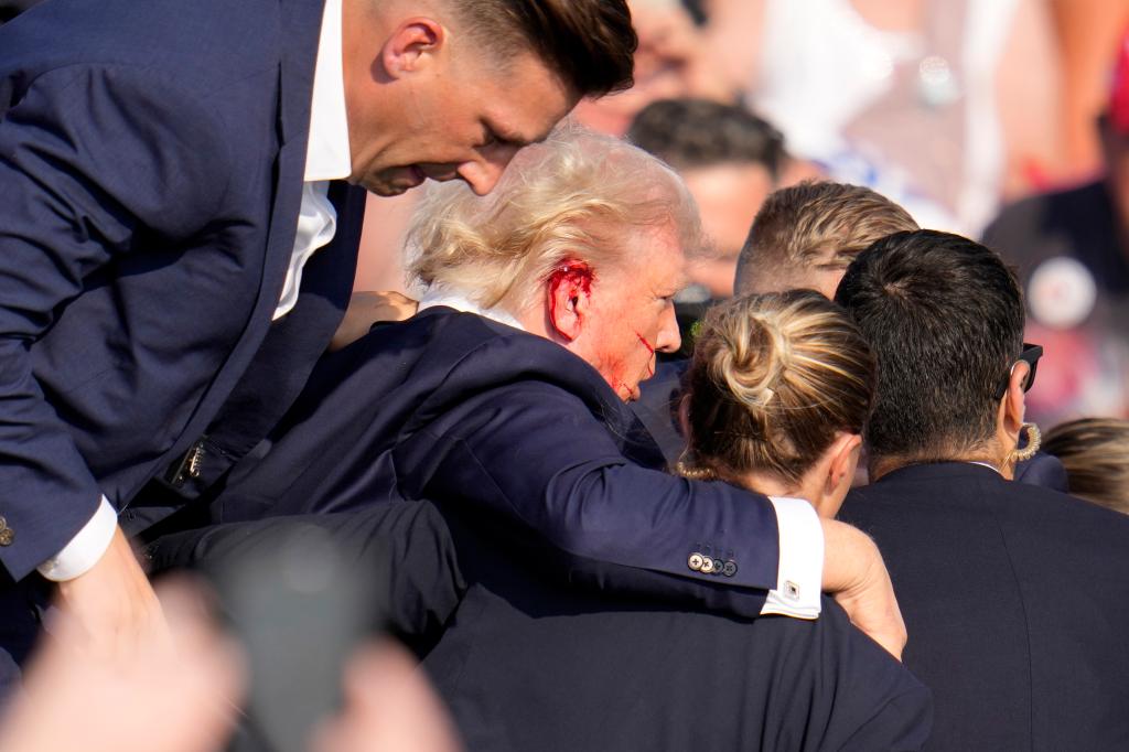 Republican presidential candidate former President Donald Trump is helped off the stage at a campaign event in Butler, Pa., on Saturday, July 13, 2024.