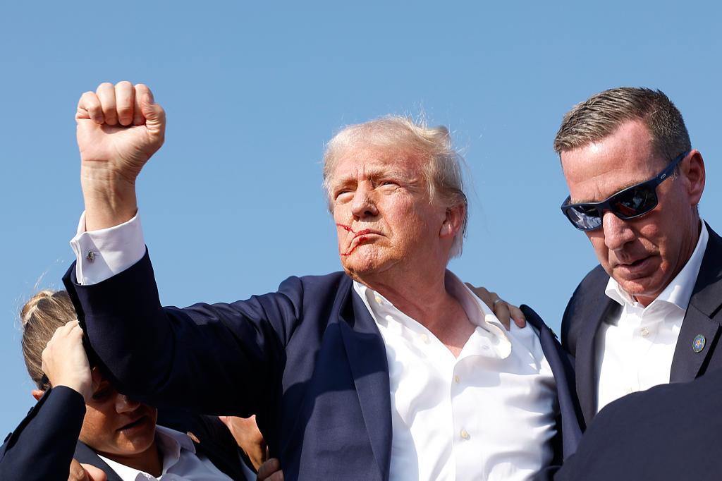 Trump raising his fist to the crowd after the shooting.