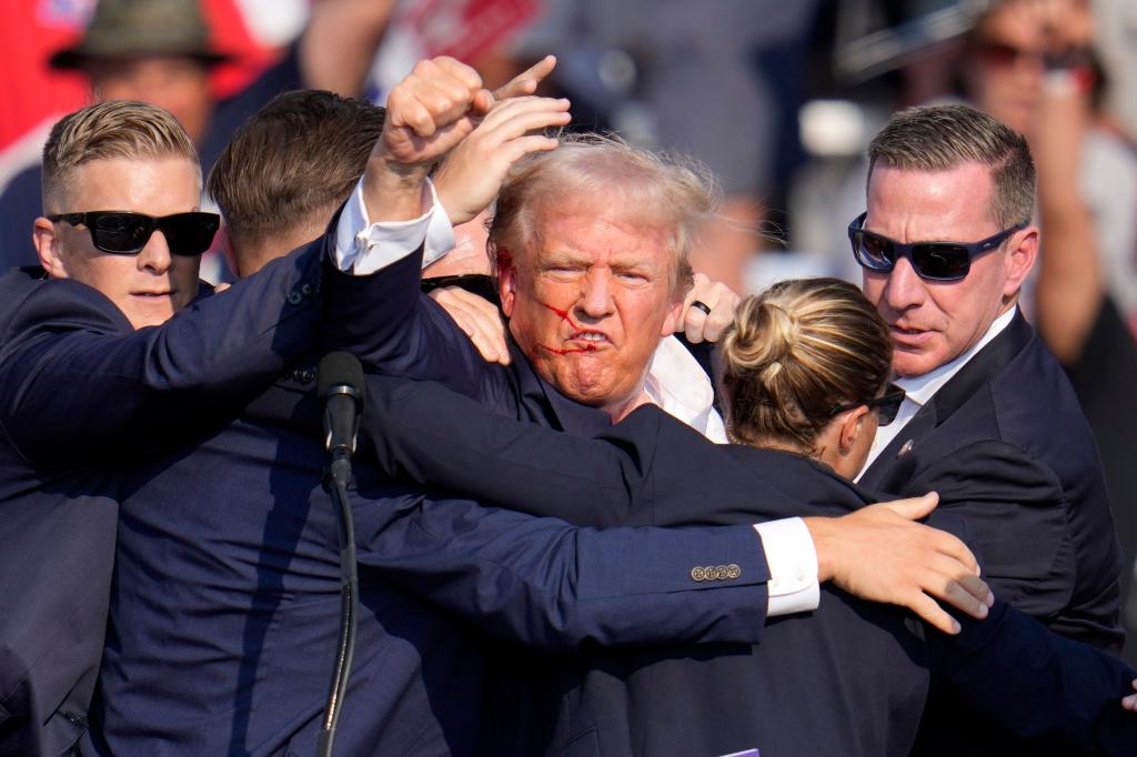 Republican presidential candidate former President Donald Trump pumps his fist as he is helped off the stage at a campaign event in Butler, Pa.