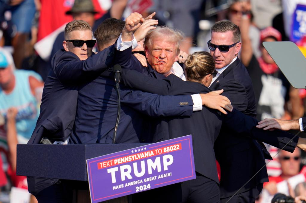 Trump raising his fist in the air after the shooting.