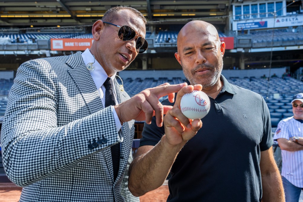 Retired Yankees Mariano Rivera demonstrates ball grip as Alex Rodriguez looks on before a game against the Los Angeles Dodgers at Yankee Stadium Saturday, June 8, 2024, in Bronx, New York.