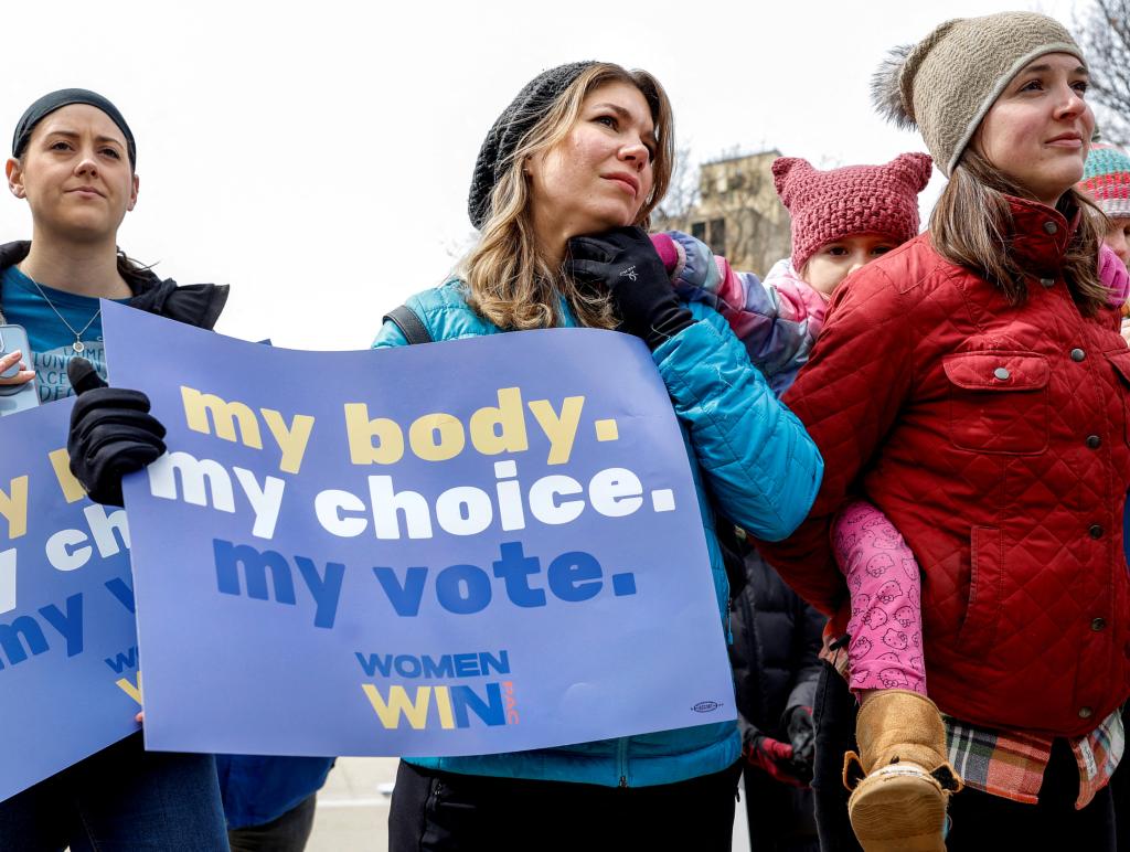 Romy Stokes and her mother Lindsey Stokes at the 'Rally for Our Rights' in front of the Wisconsin State Capitol, holding a sign advocating for abortion rights