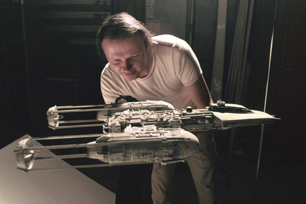 A man looks on at a "Star Wars" Y-wing filming miniature.