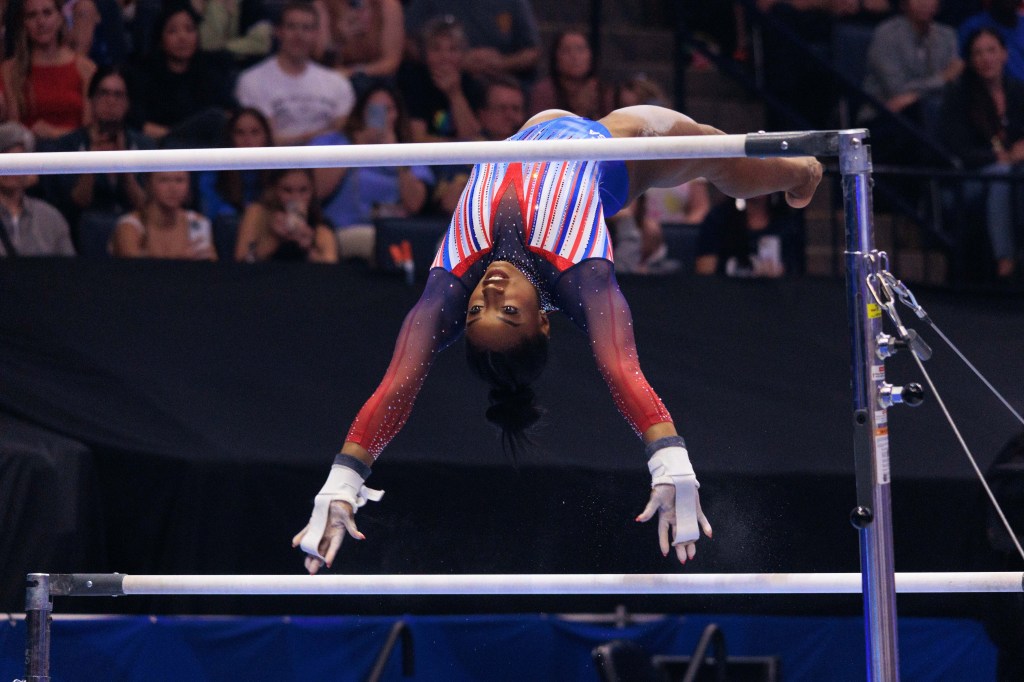 Simone Biles in the air doing gymnastics. 