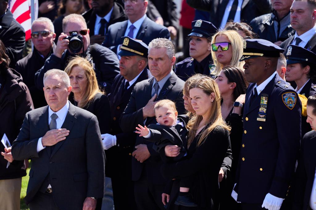 Diller's wife Stephanie carrying their 1-year-old son Ryan during the funeral.