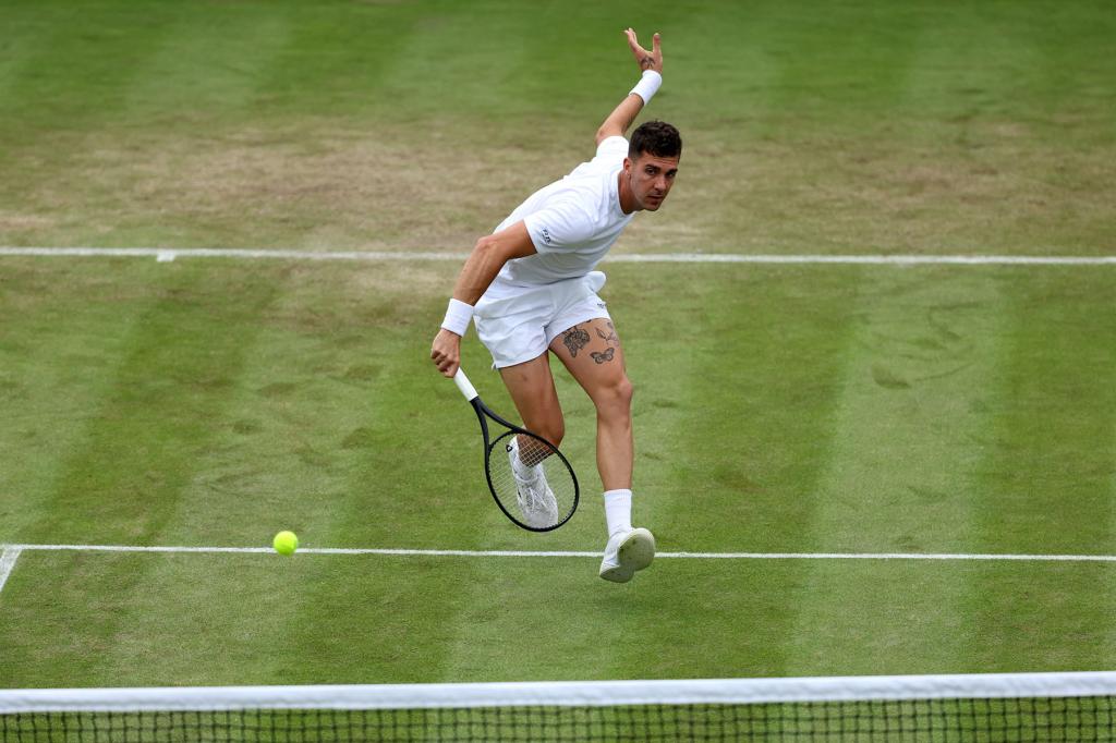 Thanasi Kokkinakis of Australia plays a backhand volley against Felix Auger-Aliassime of Canada in his Gentlemen's Singles first round match during day three of The Championships Wimbledon 2024 at All England Lawn Tennis and Croquet Club on July 03, 2024 in London, England. 