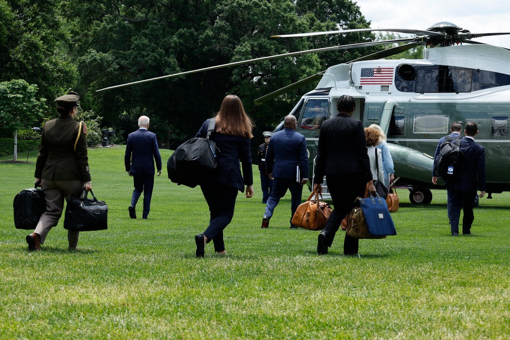 Biden is accompanied by staff and security as he walks across the South Lawn of the White House before departing on the Marine One helicopter on May 29, 2024 in Washington, DC. 