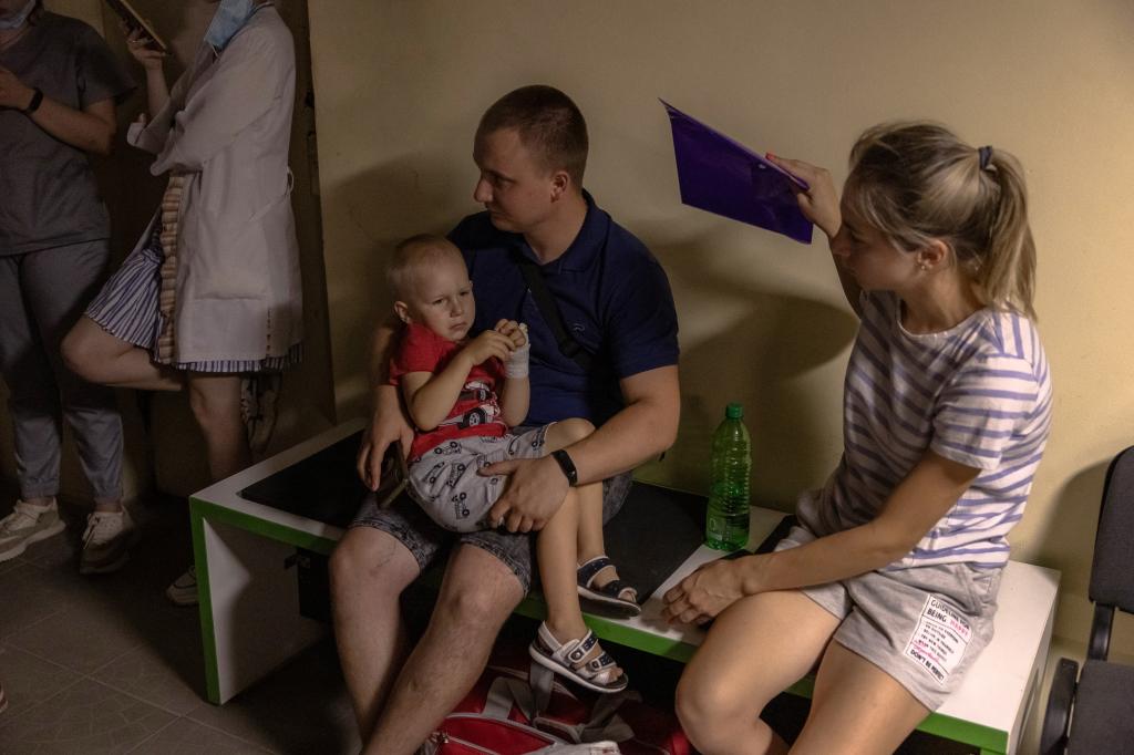 Ukrainian families take shelter during an alarm in the basement of a heavily damaged building at Ohmatdyt Children's Hospital
