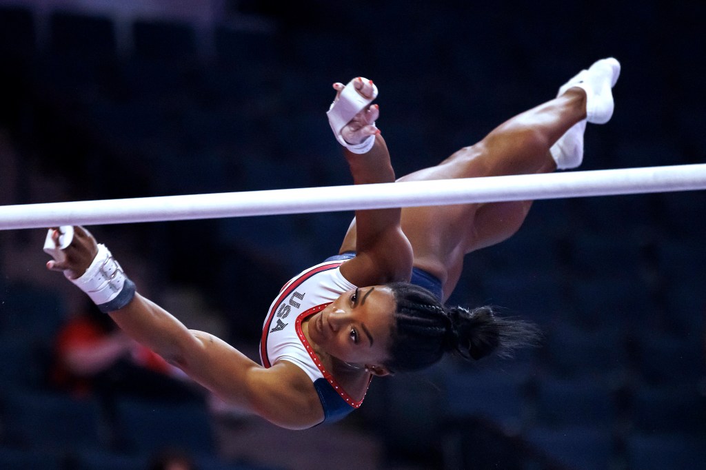 Simone Biles in the air doing a flip. 