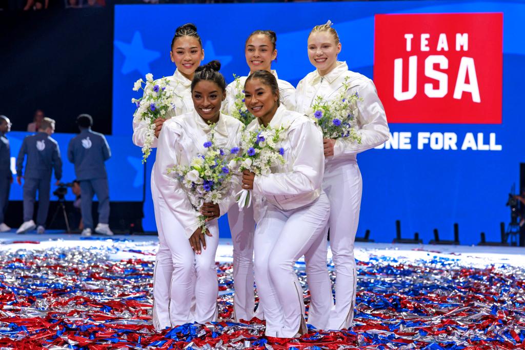 US gymnasts Suni Lee, Simone Biles, Hezly Rivera, Jordan Chiles, Jade Carey, and alternate Leanne Wong posing together after being selected for the 2024 Paris Olympics
