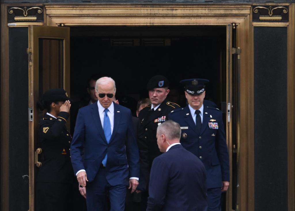 US President Joe Biden exiting Walter Reed Army Medical Center in Bethesda with a group of men in military uniforms, after his annual physical on February 28, 2024.