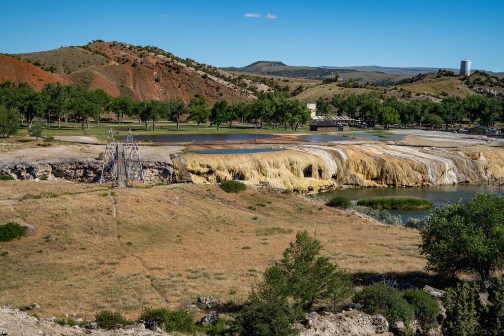 Landscape view of Hot Springs State Park in Thermopolis, Wyoming featuring a river and trees in a geothermal area