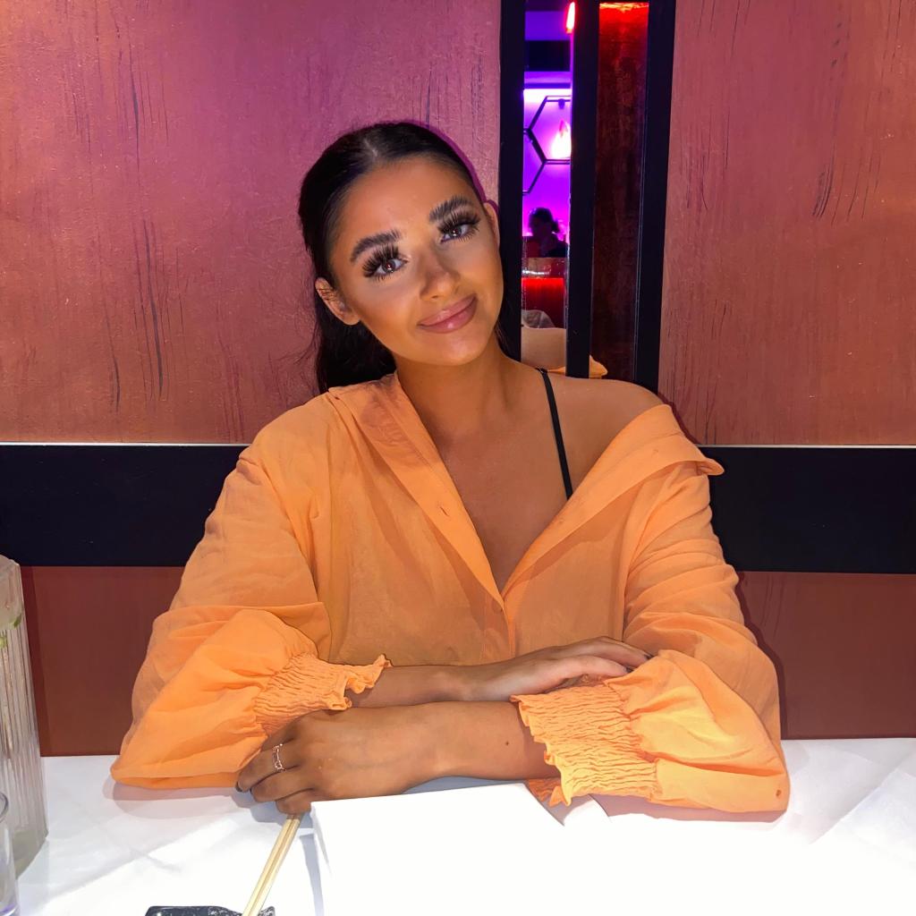 Louise Hunt, a woman with long dark hair, shown in a photo sitting at a table wearing an orange blouse. She was one of three victims of the crime.