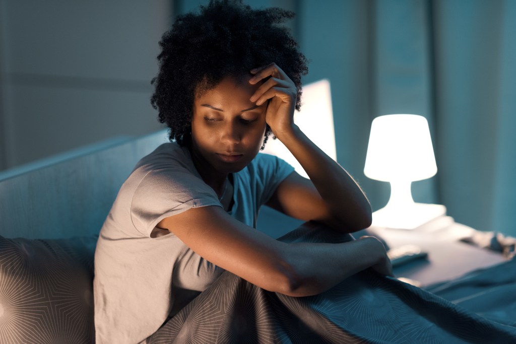 Young stressed woman suffering from insomnia, she can't sleep and she has a headache