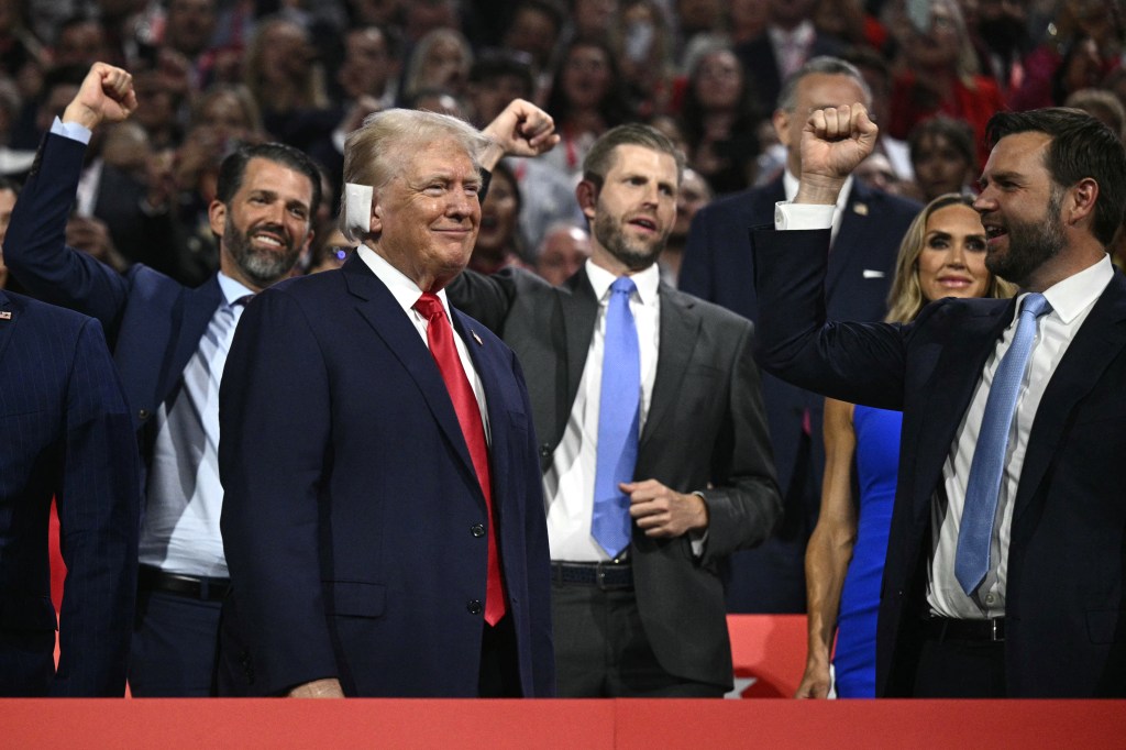 Donald Trump (bottom L) smiles as he is cheered on by US Senator from Ohio and 2024 Republican vice-president candidate J. D. Vance (R) and his sons Donald Trump Jr. and Eric Trump.