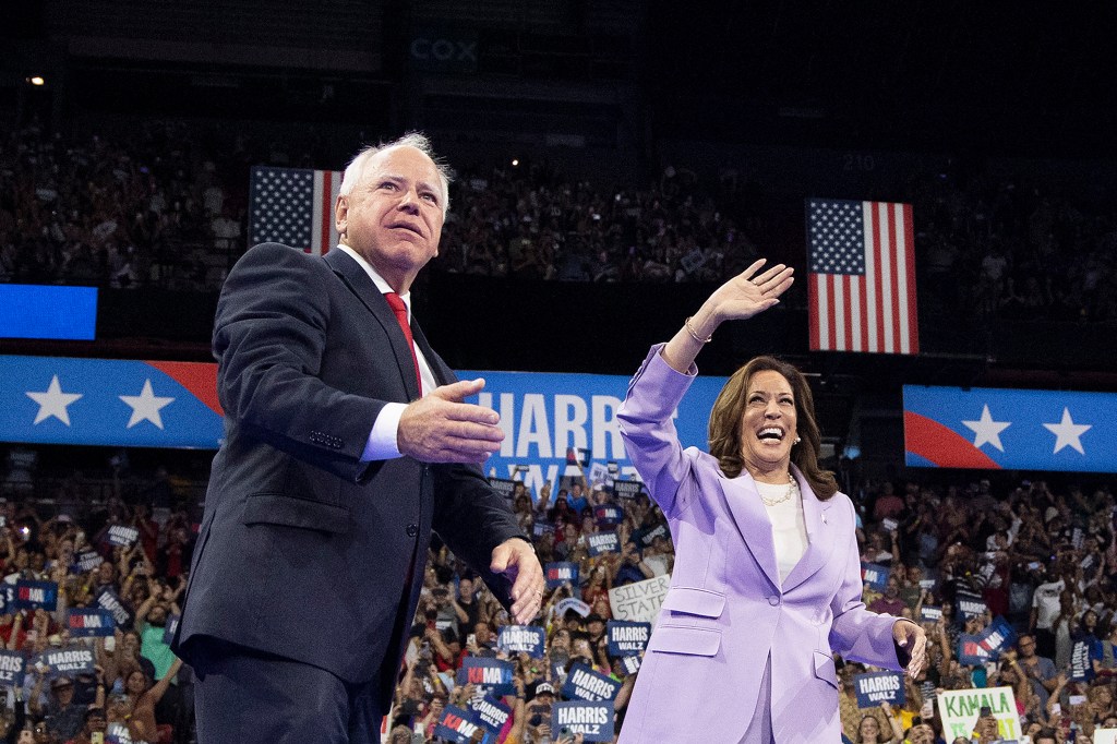 Harris (R) and Minnesota Governor and vice presidential candidate Tim Walz gesture during a campaign rally at the Thomas and Mack Center, University of Nevada in Las Vegas, Nevada, on August 10, 2024. 