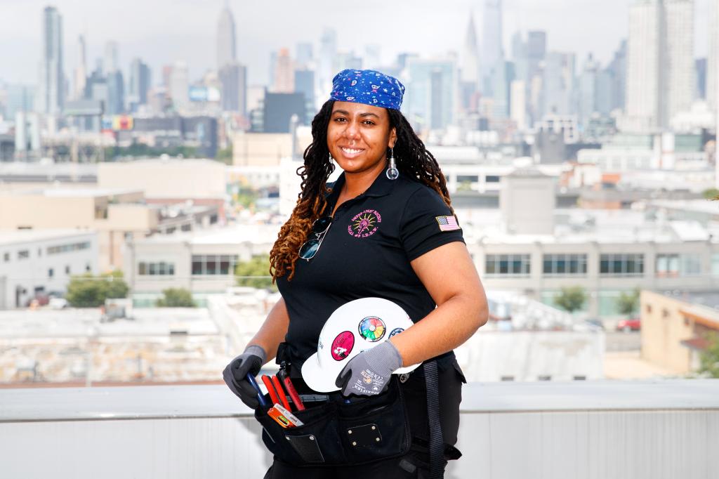 Shauna Irving on a rooftop, NYC skyline behind her. 