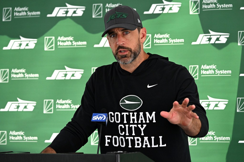 Aaron Rodgers talks with the media after the Jets' training camp practice on Aug. 13, 2024.