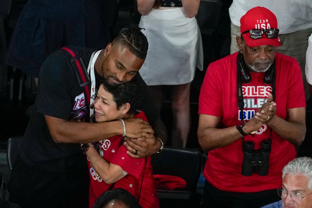 U.S. gymnast Simone Biles' husband Jonathan Owens hugs her mother Nellie Biles as she is awarded the gold medal during the women's artistic gymnastics all-around finals in Bercy Arena at the 2024 Summer Olympics, Thursday, Aug. 1, 2024, in Paris, France. 