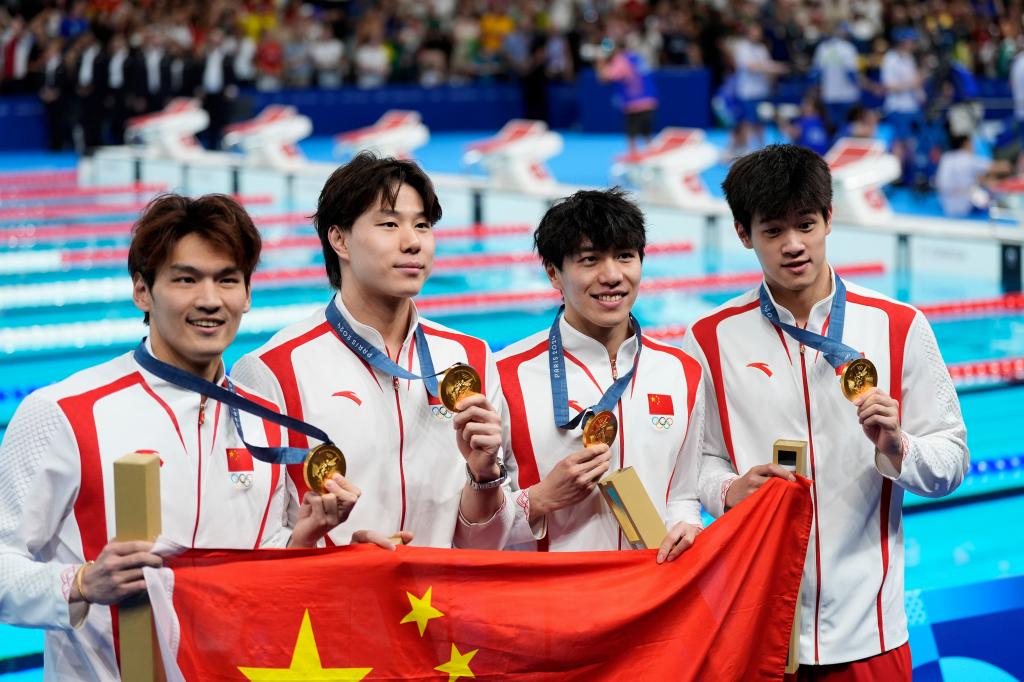 China's Xu Jiayu, Qin Haiyang, Sun Jiajun, and Pan Zhanle pose for a photo with their gold medals during the awards ceremony for the men's 4x100-meter medley relay.