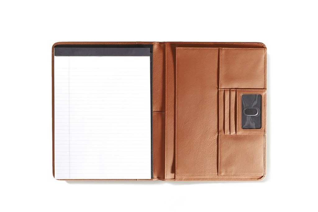 A leather folder with a notepad and a phone