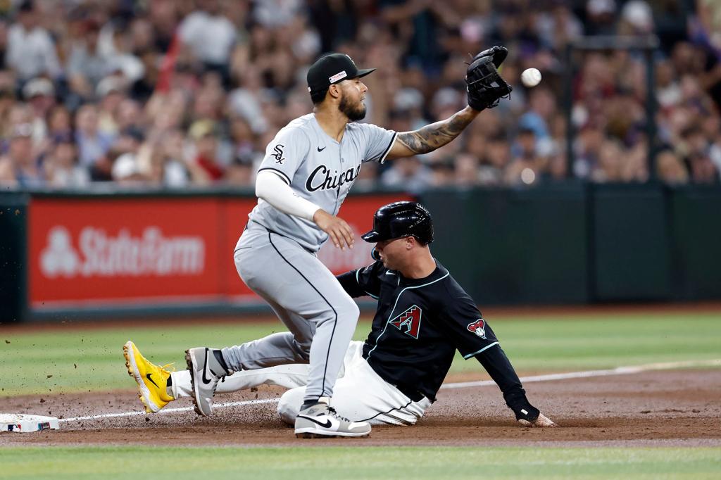 Joc Pederson #3 of the Arizona Diamondbacks safely slides into third base ahead of the throw to Lenyn Sosa #50 of the Chicago White Sox after a throwing error by catcher Korey Lee #26 during the third inning at Chase Field on June 14, 2024 in Phoenix, Arizona. 