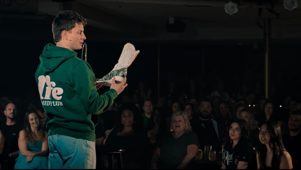 Matt Rife holding a cowboy boot. 