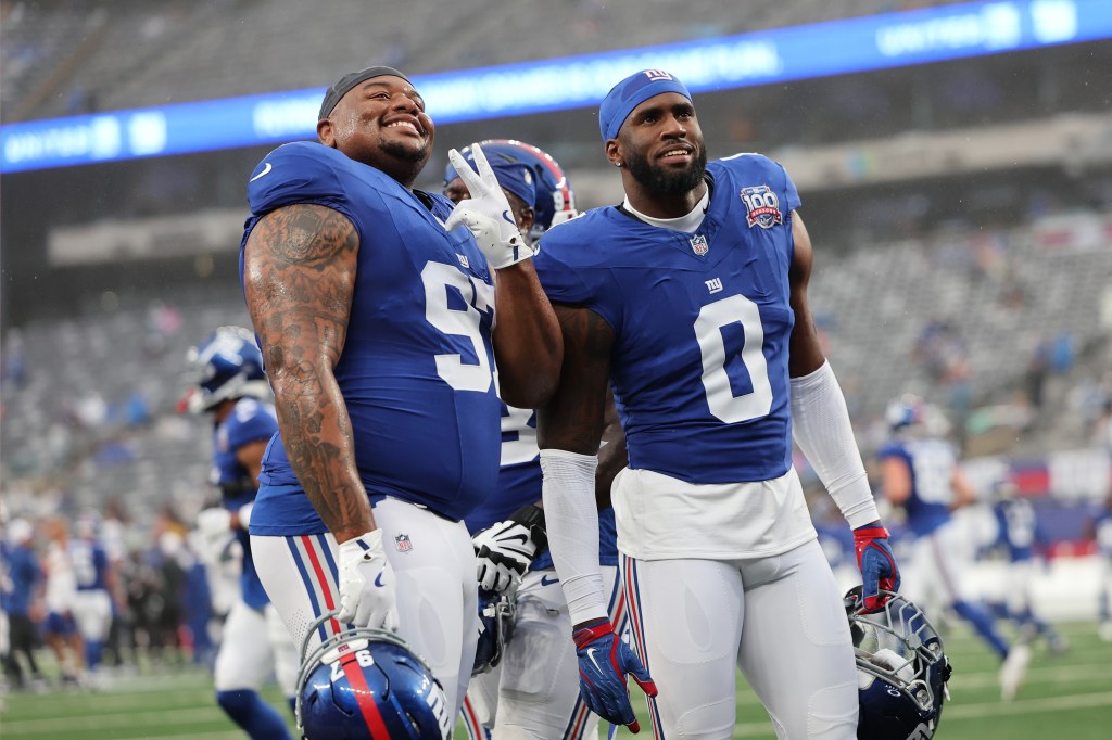 Dexter Lawrence ll #97 and Brian Burns #0 of the New York Giants warm up before a preseason game against the Detroit Lions