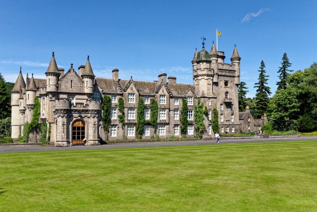 Balmoral Castle, a Scottish baronial revival style structure with towers, set amidst lush grounds in summer, the royal family's summer residence in Aberdeenshire, Scotland.